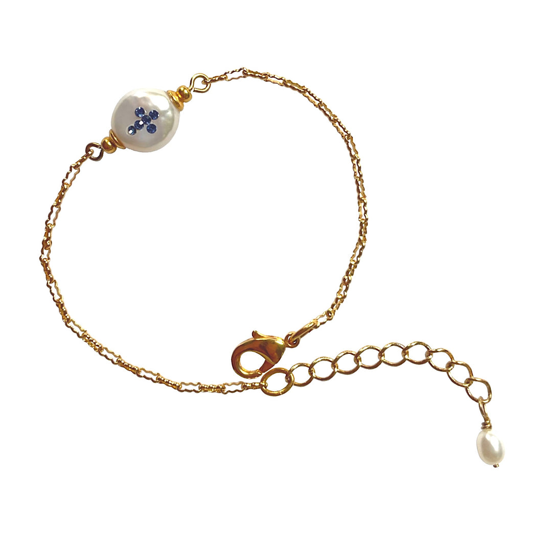 Natural, high quality Freshwater Pearl in Cream White color is inlaid with Bohemian Crystals in Sapphire, finished with 24K Gold plated corrugated link chain. The bracelet measures 6.5